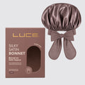 Brown satin bonnet with bow and LUCE packaging on a light gray background