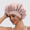 Woman wearing a pink satin bonnet on a plain background